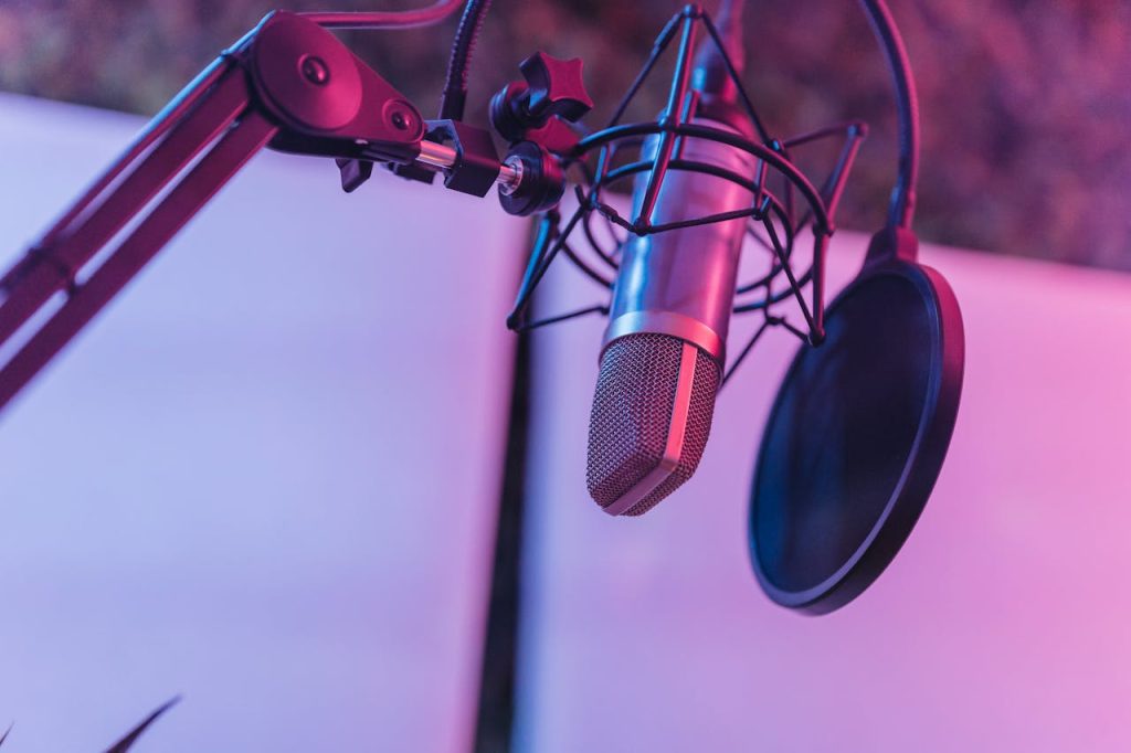 close-up-of-professional-microphone-equipment-in-studio-8132520 A close-up view of a microphone in a vibrant studio environment, ideal for podcasts and voice recording.