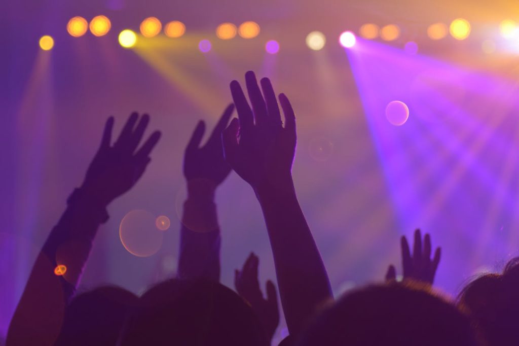group-of-people-in-a-concert-1587927 Silhouettes of a lively audience with raised hands at an energetic nightclub event.